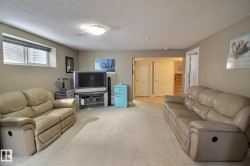 This inviting living area features carpeted floors, light beige walls, and a window with horizontal blinds - 