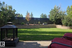The property features an extensive yard with a well-maintained lawn and a paved patio area - 