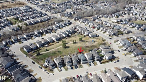 Aerial view of a residential neighborhood with detached homes, paved streets, and green spaces - 1212 Westerra Crescent, Stony Plain, AB - 