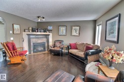 Living room featuring dark hardwood floors, a fireplace with a tile surround and mantel, and painted walls - 