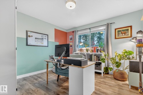 This room features wood-look flooring, a large window, and light-colored walls - 7408 92 Avenue, Edmonton, AB - Indoor Photo Showing Office