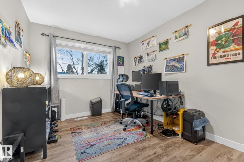 This versatile room features light-colored walls and hardwood-style flooring, creating a bright and adaptable space - 7408 92 Avenue, Edmonton, AB - Indoor Photo Showing Office