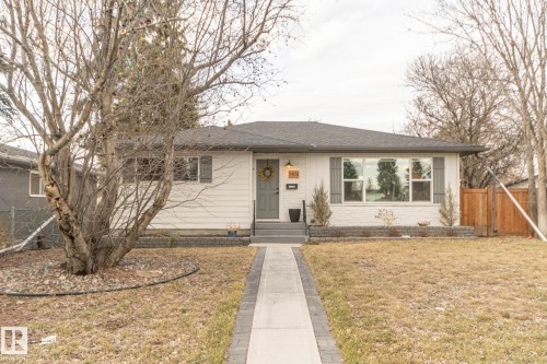The property features a ranch-style exterior with white siding and a dark gray roof - 7408 92 Avenue, Edmonton, AB - Outdoor