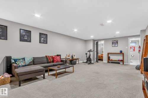 Spacious entertainment room featuring light gray walls, recessed lighting, and carpeted flooring - 7408 92 Avenue, Edmonton, AB - Indoor Photo Showing Basement