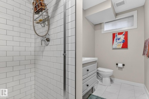 The bathroom features a shower with white subway tile walls and a chrome shower fixture - 7408 92 Avenue, Edmonton, AB - Indoor Photo Showing Bathroom