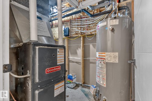 The property includes a Goodman furnace and a water heater, both visible in this utility area - 7408 92 Avenue, Edmonton, AB - Indoor Photo Showing Basement