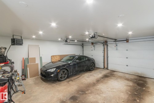 The property features a garage with a concrete floor, equipped with recessed lighting and two overhead garage doors - 7408 92 Avenue, Edmonton, AB - Indoor Photo Showing Garage