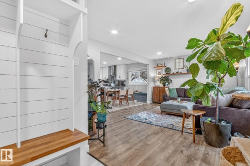 The property features an open-concept living area with wood-style flooring throughout - 7408 92 Avenue, Edmonton, AB - Indoor Photo Showing Living Room