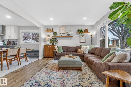 This bright living area features recessed lighting, hardwood style flooring, and large windows - 7408 92 Avenue, Edmonton, AB - Indoor Photo Showing Living Room