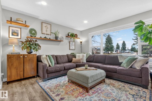 Living area featuring hardwood flooring, recessed lighting, and large windows providing ample natural light - 7408 92 Avenue, Edmonton, AB - Indoor Photo Showing Living Room