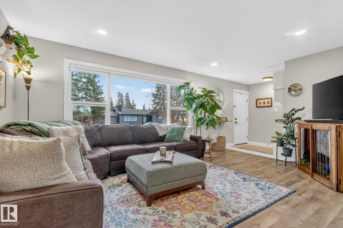 The living area features light-toned walls, recessed lighting, and large windows - 7408 92 Avenue, Edmonton, AB - Indoor Photo Showing Living Room