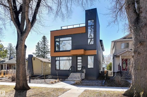 Contemporary architectural design featuring dark gray siding and natural wood-look accents - 9741 90 Avenue, Edmonton, AB - Outdoor