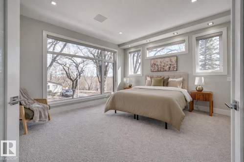 Spacious room featuring floor-to-ceiling windows, soft gray carpeting, recessed lighting, and white trim - 9741 90 Avenue, Edmonton, AB - Indoor Photo Showing Bedroom