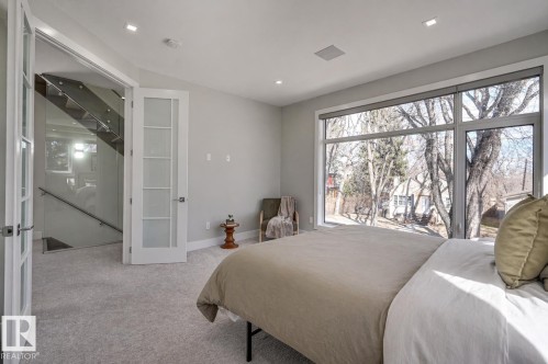 Bedroom featuring a large picture window, recessed lighting, and light-toned carpeting - 9741 90 Avenue, Edmonton, AB - Indoor Photo Showing Bedroom