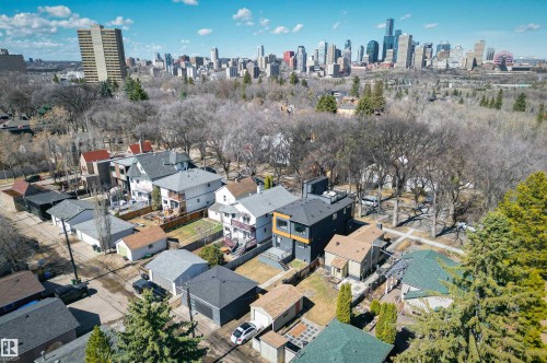 Aerial perspective showcasing a residential neighborhood with varied architectural styles, mature trees, and a distant city skyline - 9741 90 Avenue, Edmonton, AB - Outdoor With View
