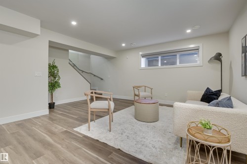 Spacious room featuring wood-finish flooring, recessed lighting, and a neutral color palette - 9741 90 Avenue, Edmonton, AB - Indoor