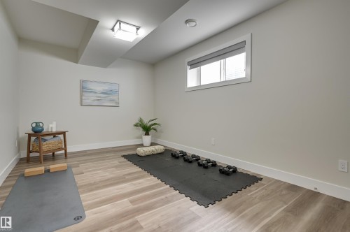 Room with light wood-finish flooring, a rectangular window with a roller blind, and recessed ceiling lighting - 9741 90 Avenue, Edmonton, AB - Indoor Photo Showing Other Room