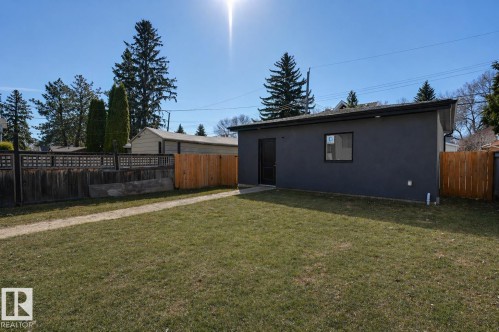 Detached structure featuring dark gray stucco exterior, flat roofline, and a single black-framed window - 9741 90 Avenue, Edmonton, AB - Outdoor