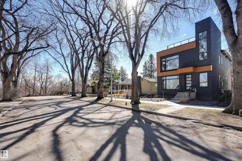 Modern dark-toned exterior featuring wood-finish accent panels and multiple large windows - 9741 90 Avenue, Edmonton, AB - Outdoor