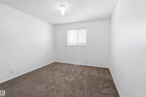 Room featuring clean white walls, carpeted flooring, and a single window with blinds - 6009 36 Avenue, Beaumont, AB - Indoor Photo Showing Other Room
