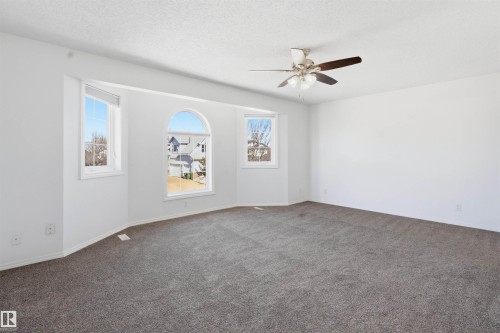 Spacious room featuring neutral carpeting, white walls, and a ceiling fan - 6009 36 Avenue, Beaumont, AB - Indoor Photo Showing Other Room
