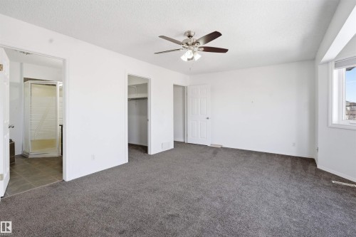 Spacious room featuring gray carpeting, white walls, a ceiling fan with light fixture, and a window providing natural light - 6009 36 Avenue, Beaumont, AB - Indoor Photo Showing Other Room