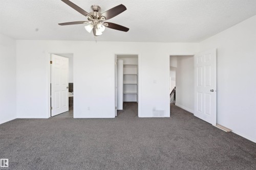 This space features neutral-toned carpet, a ceiling fan with integrated lighting, and white walls - 6009 36 Avenue, Beaumont, AB - Indoor Photo Showing Other Room