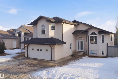 The property features a stucco exterior, a dark shingled roof, and a front-facing garage with a white door - 6009 36 Avenue, Beaumont, AB - Outdoor