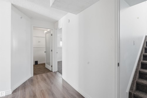 This property features a bright hallway with light-colored walls and wood-look flooring - 6009 36 Avenue, Beaumont, AB - Indoor Photo Showing Other Room