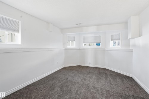 This room features neutral white walls, grey carpeting, and windows with blinds - 6009 36 Avenue, Beaumont, AB - Indoor Photo Showing Other Room