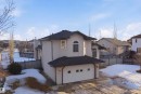 The property features a stucco exterior, a dark shingled roof, and a double garage with a white door - 6009 36 Avenue, Beaumont, AB  - Outdoor 