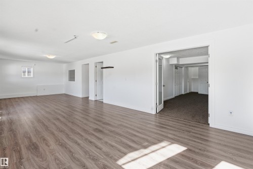 This versatile space features light-toned wood flooring, bright white walls, and recessed lighting - 6009 36 Avenue, Beaumont, AB - Indoor Photo Showing Other Room