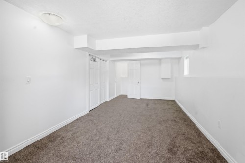 This room features light-colored walls, gray carpeting, and a window providing natural light - 6009 36 Avenue, Beaumont, AB - Indoor Photo Showing Other Room