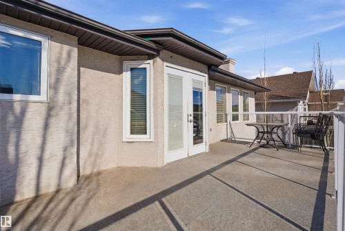 An expansive outdoor deck space, featuring a durable concrete surface and a white railing system, provides an ideal setting for relaxation - 6009 36 Avenue, Beaumont, AB - Outdoor With Exterior