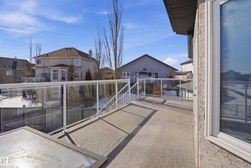 Outdoor deck with glass railing, providing an open view of the surrounding properties and winter landscaping - 6009 36 Avenue, Beaumont, AB - Outdoor With Exterior