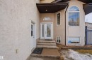 The property features a textured stucco exterior, an arched transom window above the main entry, and a large arched picture window on the upper level - 6009 36 Avenue, Beaumont, AB  - Outdoor 