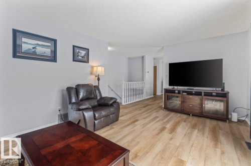 Open concept living area featuring light wood-finish flooring, neutral wall tones, and white trim - 219 Knottwood Road N, Edmonton, AB - Indoor Photo Showing Living Room