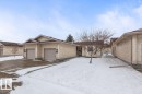 Exterior featuring neutral stucco siding, brown asphalt shingle roofing, and a two-car attached garage with individual doors - 219 Knottwood Road N, Edmonton, AB  - Outdoor 