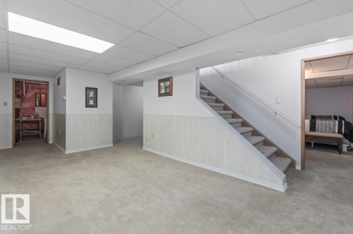 Carpeted lower level featuring a drop ceiling, recessed lighting, and chair rail molding - 219 Knottwood Road N, Edmonton, AB - Indoor Photo Showing Other Room