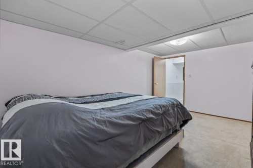 Spacious room featuring neutral-toned walls, recessed ceiling panels, and a flush-mount ceiling light fixture - 219 Knottwood Road N, Edmonton, AB - Indoor Photo Showing Bedroom