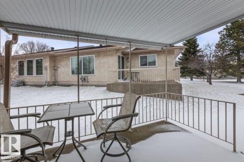 Covered patio area with concrete flooring and metal railings - 219 Knottwood Road N, Edmonton, AB - Outdoor With Deck Patio Veranda