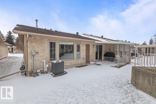 Rear exterior featuring stucco finish, a covered patio area, and a large picture window - 219 Knottwood Road N, Edmonton, AB - Outdoor With Deck Patio Veranda With Exterior