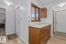 Entryway featuring wood-finish flooring, white walls, and a built-in wood cabinetry unit with a light-toned countertop - 219 Knottwood Road N, Edmonton, AB  - Indoor 