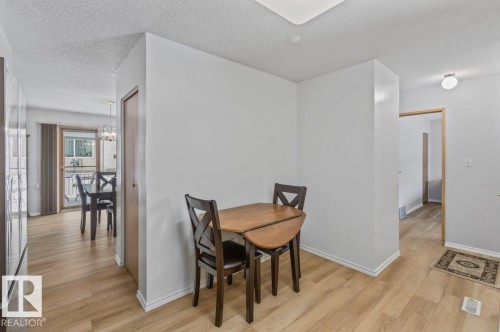Light wood-finish flooring extends throughout this interior space - 219 Knottwood Road N, Edmonton, AB - Indoor Photo Showing Dining Room
