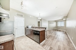 The property features a kitchen with dark cabinetry, stone-look countertops, and stainless steel appliances - 