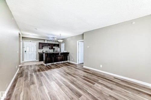 Open-concept living space featuring wide plank flooring and light-toned walls - 411 6925 199 Street Nw, Edmonton, AB - Indoor Photo Showing Other Room