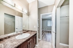 The bathroom features a vanity with a countertop and a single basin sink - 