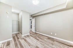 This room features wood-look flooring, light-toned walls, and a recessed ceiling detail - 