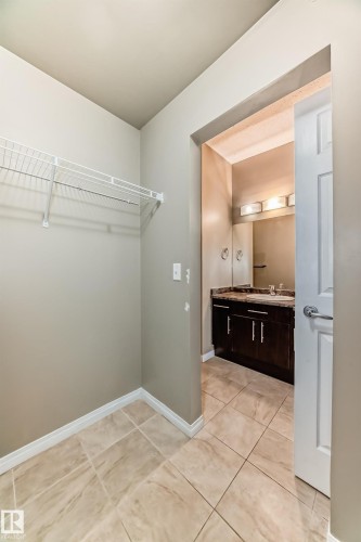 This area features light-colored tile flooring and a wire shelving system - 411 6925 199 Street Nw, Edmonton, AB - Indoor