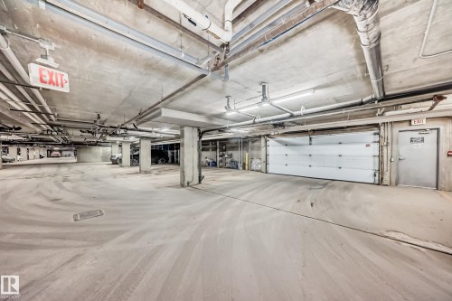Spacious underground parking garage with concrete floors and overhead lighting - 411 6925 199 Street Nw, Edmonton, AB - Indoor Photo Showing Garage